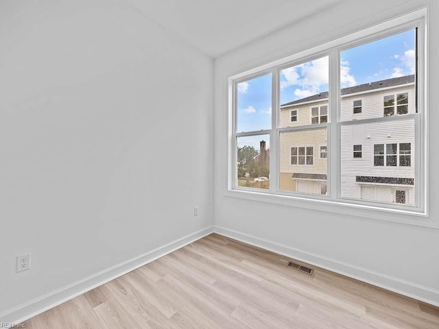 unfurnished room featuring light wood-type flooring and a healthy amount of sunlight