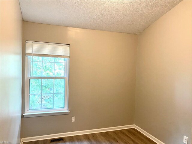 spare room with wood-type flooring and a textured ceiling