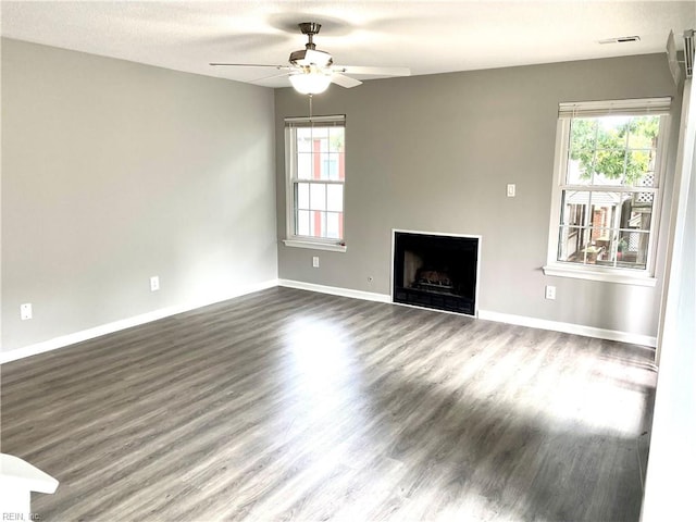 unfurnished living room with ceiling fan, dark hardwood / wood-style floors, and a textured ceiling