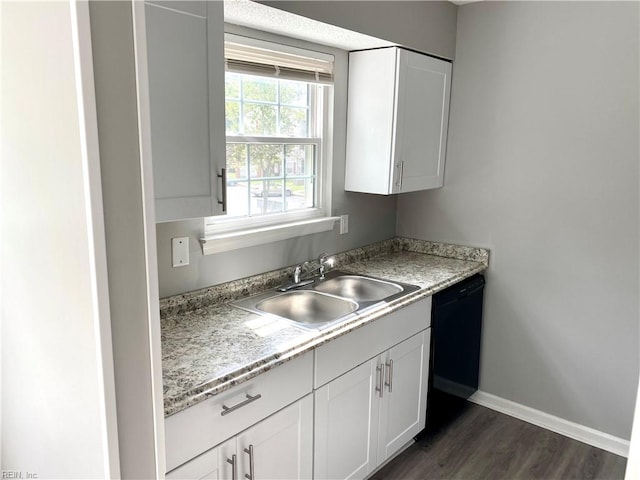 kitchen with white cabinetry, dark wood-type flooring, dishwasher, light stone countertops, and sink