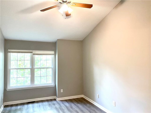 unfurnished room featuring vaulted ceiling, ceiling fan, and dark wood-type flooring