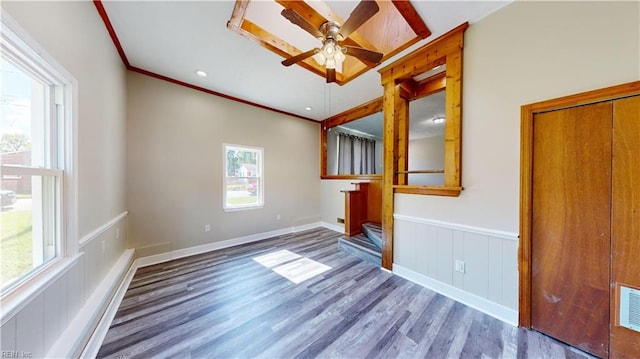 empty room with wood-type flooring, ceiling fan, and crown molding