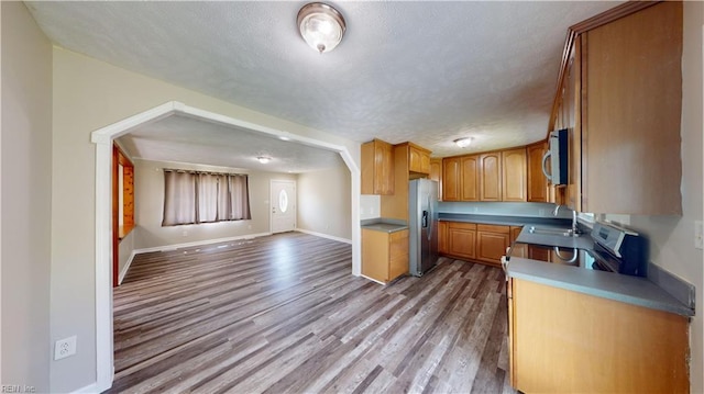 kitchen featuring light hardwood / wood-style flooring, stainless steel appliances, a textured ceiling, and sink