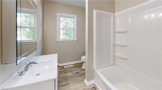 full bathroom featuring shower / bathing tub combination, wood-type flooring, vanity, and toilet