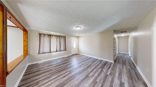 empty room with hardwood / wood-style flooring and a textured ceiling