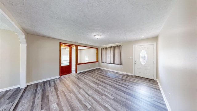 entryway with a textured ceiling and hardwood / wood-style flooring