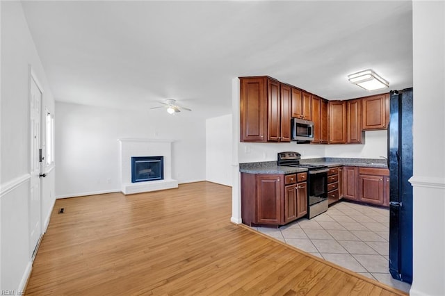 kitchen featuring appliances with stainless steel finishes, light wood-type flooring, and ceiling fan