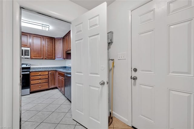 kitchen with appliances with stainless steel finishes and light tile patterned flooring