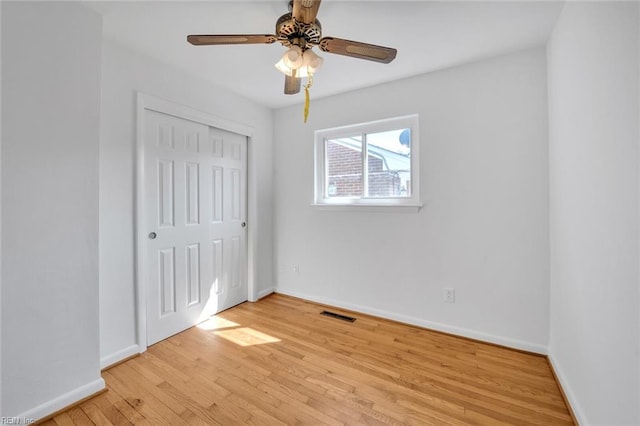 unfurnished bedroom featuring light hardwood / wood-style flooring, a closet, and ceiling fan