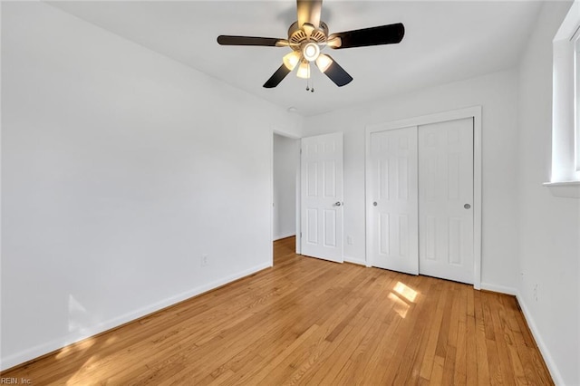 unfurnished bedroom featuring light wood-type flooring, ceiling fan, and a closet