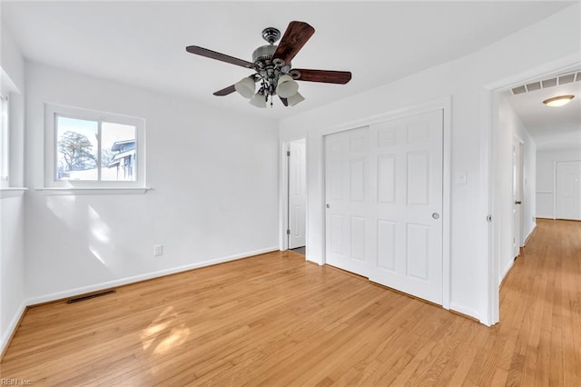 unfurnished bedroom featuring ceiling fan, a closet, and light hardwood / wood-style floors