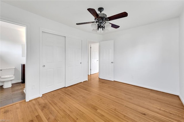 unfurnished bedroom featuring ceiling fan, light hardwood / wood-style flooring, connected bathroom, and a closet