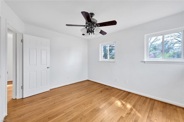 unfurnished room featuring a healthy amount of sunlight, light hardwood / wood-style floors, and ceiling fan