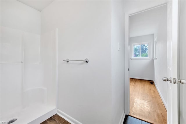 bathroom featuring a shower and hardwood / wood-style flooring