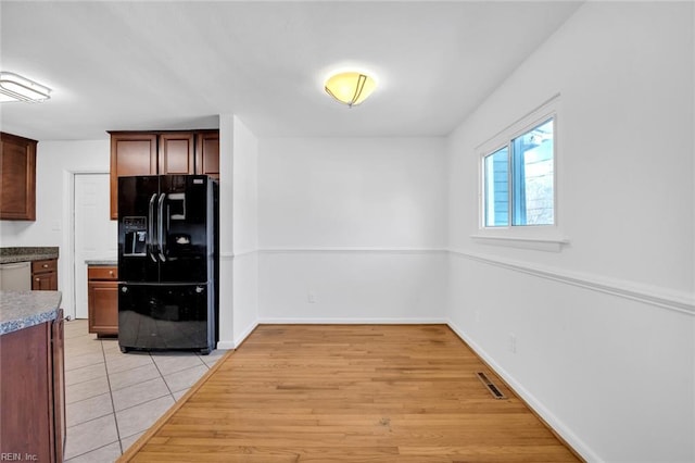 kitchen with light wood-type flooring, dishwasher, and black fridge with ice dispenser