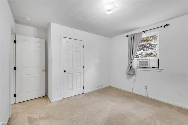 unfurnished bedroom featuring cooling unit and light colored carpet