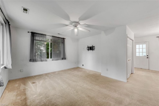 carpeted spare room featuring ceiling fan