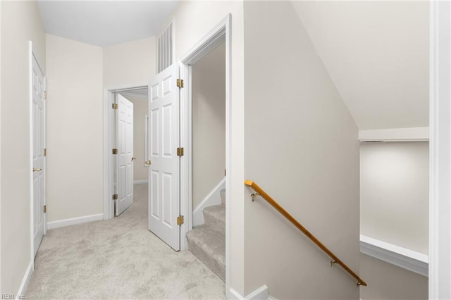 hallway featuring lofted ceiling and light colored carpet