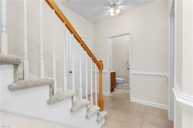 staircase featuring ceiling fan and tile patterned floors