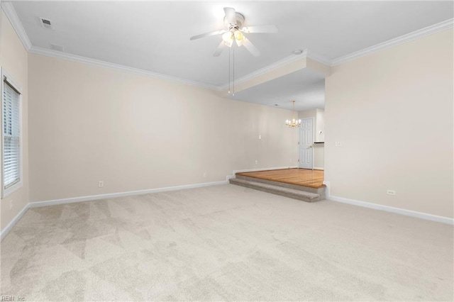 carpeted spare room with ceiling fan with notable chandelier and crown molding