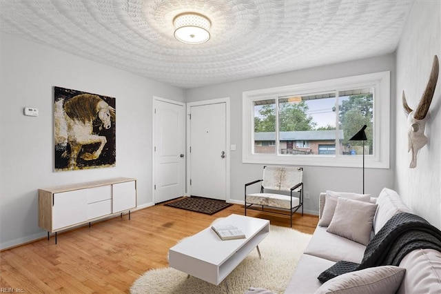 living room with light hardwood / wood-style floors and a textured ceiling