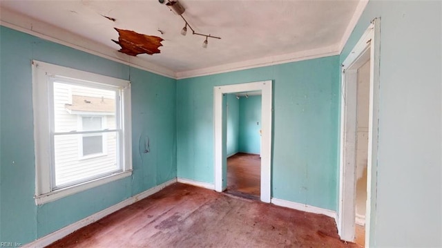 unfurnished bedroom with ornamental molding and track lighting