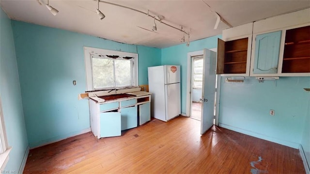 kitchen with a baseboard radiator, a wealth of natural light, light hardwood / wood-style floors, and white refrigerator