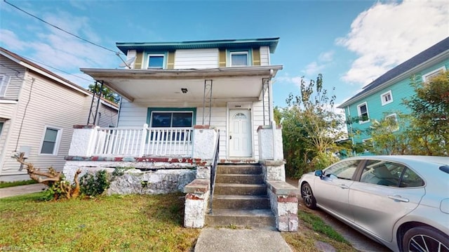 view of front of home featuring a front yard and covered porch