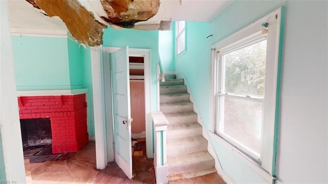 staircase with carpet floors and a fireplace