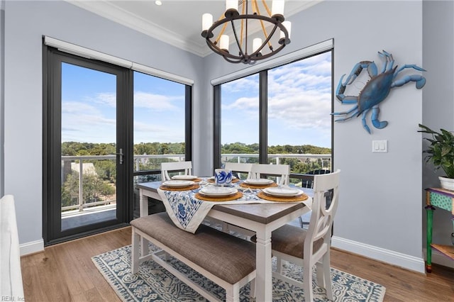 dining room with crown molding, an inviting chandelier, and hardwood / wood-style flooring