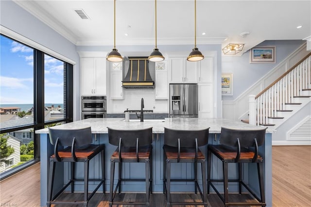 kitchen featuring white cabinets, custom exhaust hood, stainless steel appliances, and a wealth of natural light