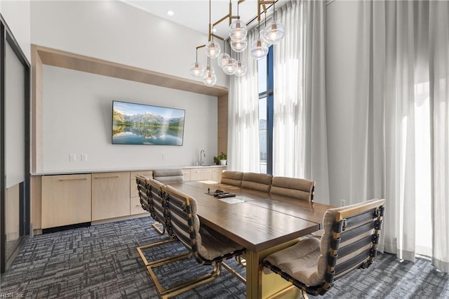 dining area featuring an inviting chandelier and dark colored carpet