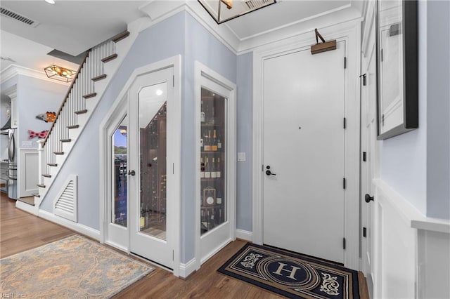 foyer entrance featuring wood-type flooring and crown molding