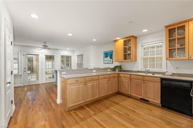 kitchen featuring ceiling fan, sink, kitchen peninsula, black dishwasher, and light wood-type flooring