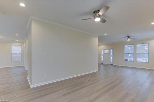 unfurnished room featuring ceiling fan, light wood-type flooring, and ornamental molding