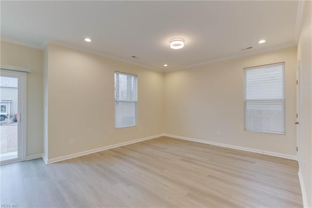 empty room featuring light hardwood / wood-style floors and crown molding