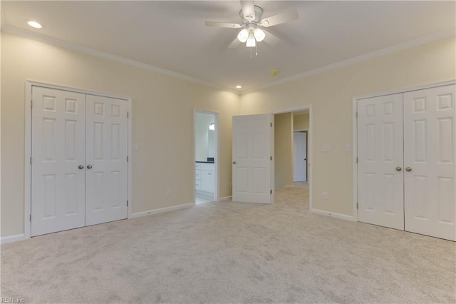 unfurnished bedroom featuring connected bathroom, ornamental molding, ceiling fan, and light colored carpet