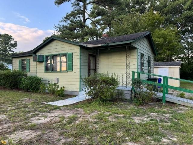 view of front of house with a storage shed and an outdoor structure