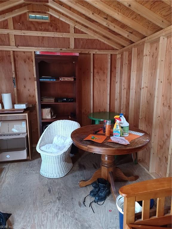 dining room with wood walls and lofted ceiling