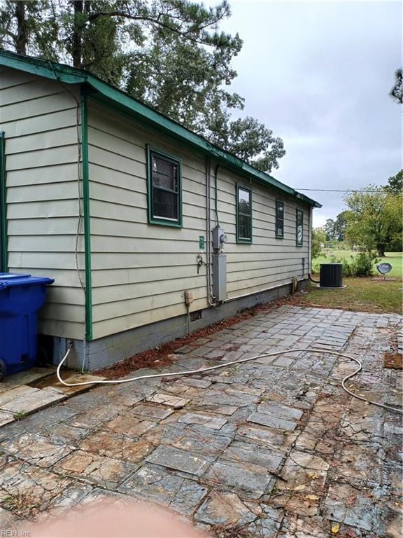 rear view of property featuring a patio, crawl space, and central air condition unit