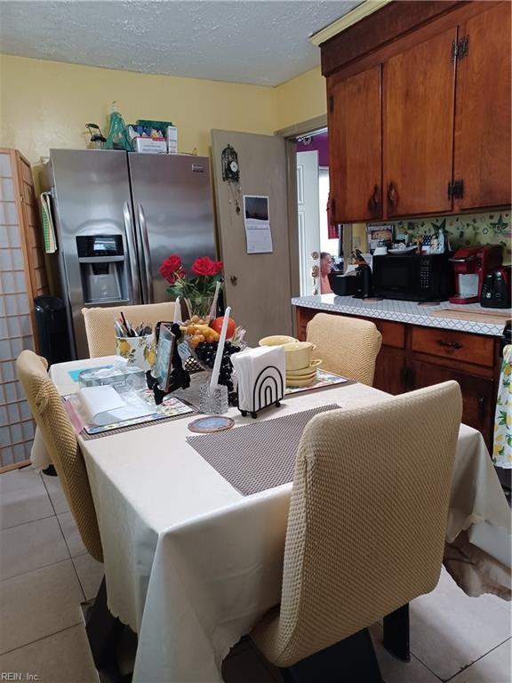 dining room featuring light tile patterned floors and a textured ceiling