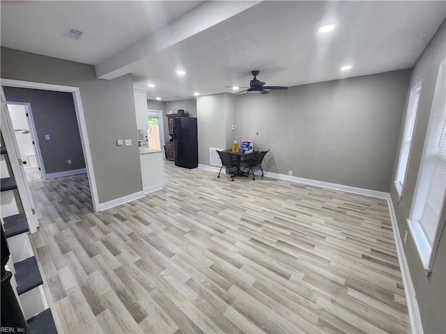 unfurnished living room featuring ceiling fan and light hardwood / wood-style flooring