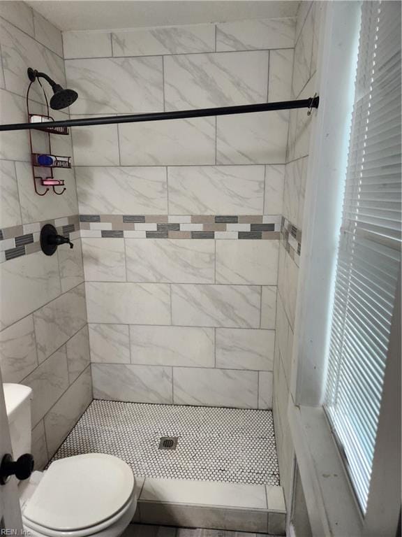 bathroom with tiled shower and toilet