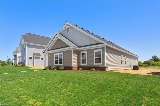 view of front of home featuring a front yard, a garage, and central AC