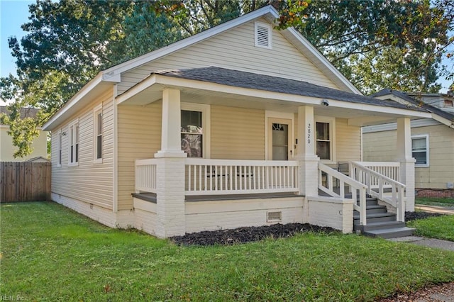 bungalow-style house featuring covered porch and a front yard