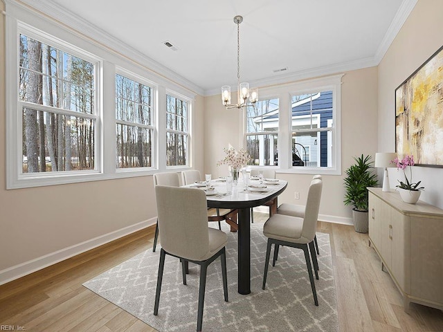 dining room with visible vents, a notable chandelier, light wood-style floors, crown molding, and baseboards