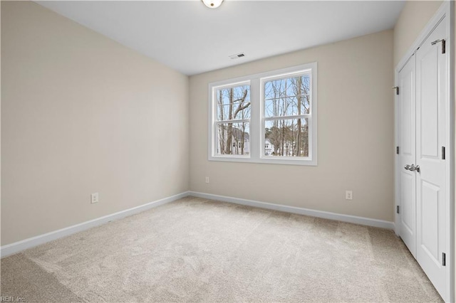 unfurnished bedroom featuring visible vents, carpet, baseboards, and a closet