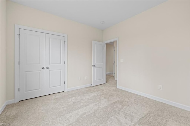 unfurnished bedroom with a closet, baseboards, and carpet