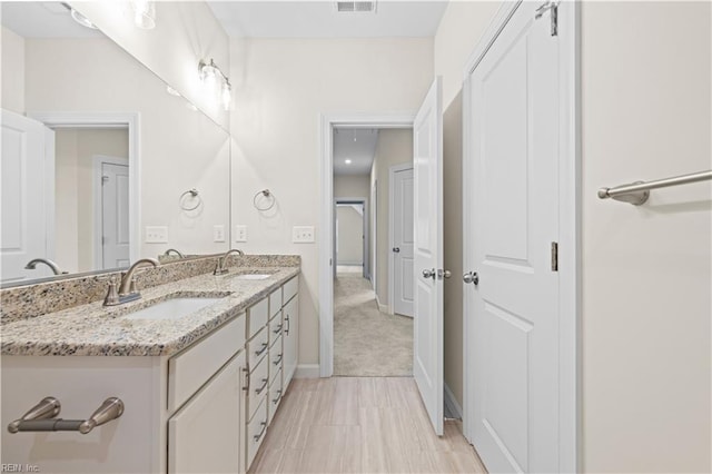 bathroom featuring double vanity, baseboards, and a sink