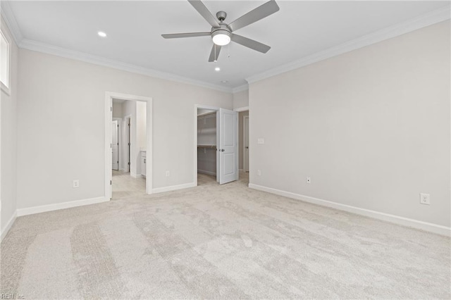 unfurnished bedroom featuring ornamental molding, recessed lighting, baseboards, light colored carpet, and a spacious closet